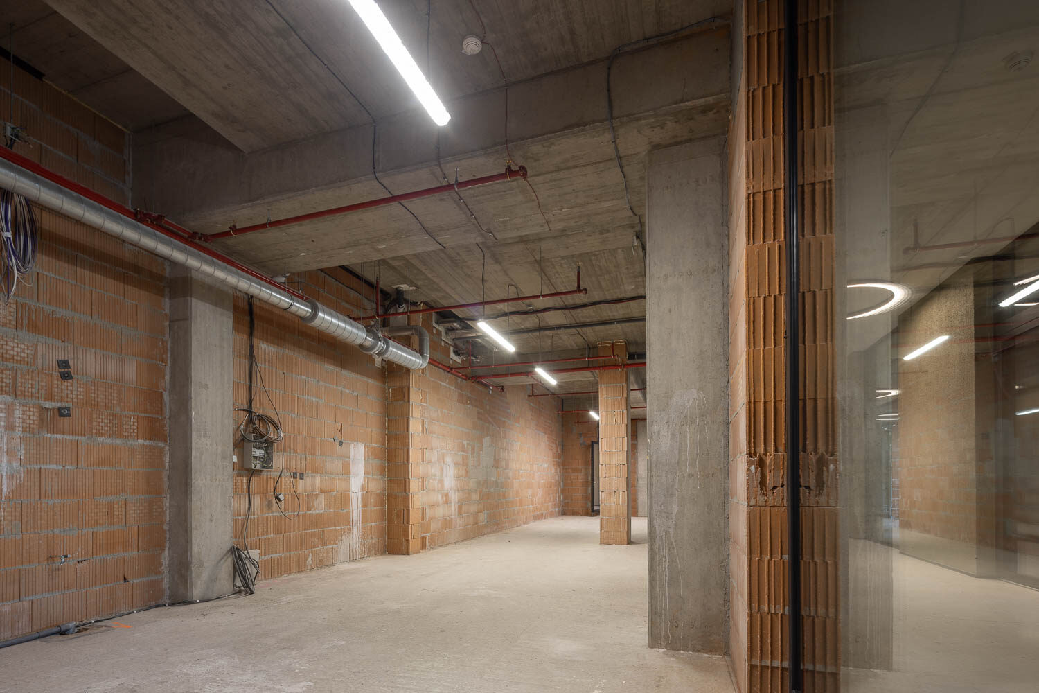 Pohled jednotkou s cihlovými stěnami a betonovými sloupy